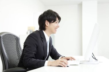 Ofiste bilgisayarla çalışan genç iş adamının portresi