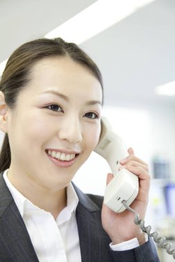 Ofiste telefon kullanan bir kadın. 