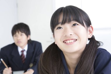 Sınıfta oturan birkaç Japon öğrenci, beyaz arkaplan. 