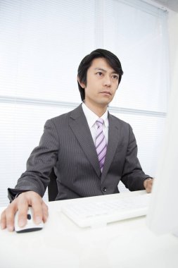 Ofiste çalışan kendinden emin genç Japon işadamı.