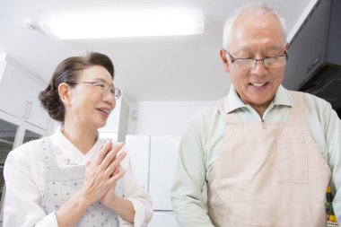 Mutfakta yemek pişiren yaşlı çift.