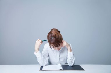 Yorgun Asyalı iş kadını ofiste geç saatlere kadar çalışıyor. 