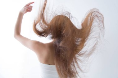 Uçan saçlı genç bir kadın, stüdyo fotoğrafı.