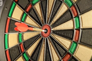 Tahtadaki oklarla hedefi dartlar.  