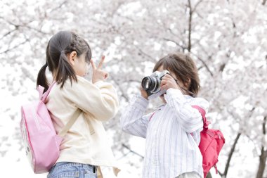 Kız kardeşinin parkında fotoğraf çeken bir çocuk. 
