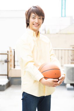 Basketbol topuyla poz veren Japon adamın portresi