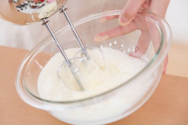 Kremalı hamuru elektrikli el mikseriyle karıştırıyorum.