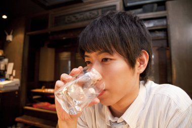 Genç Asyalı bir adamla barda içiyor. 