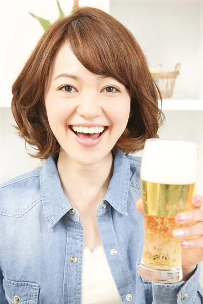 自宅でビールを飲む陽気な日本人女性 — ストック写真