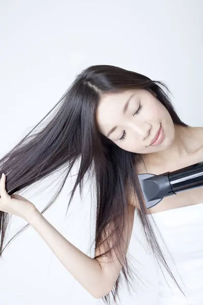 beautiful asian woman with long hair drying hair