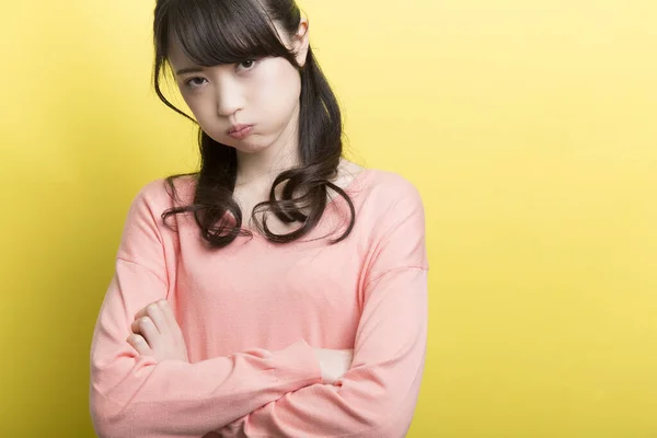 怒った若いアジアの女性は黄色の背景に唇を傾ける — ストック写真
