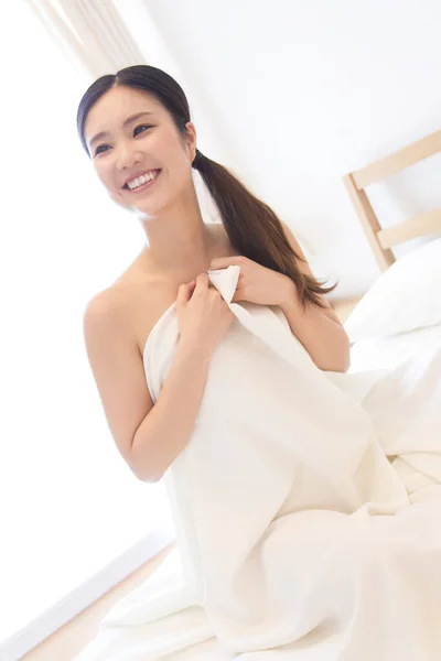 ベッドに座っている美しいアジアの若い女性 — ストック写真