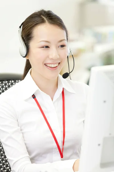 smiling Japanese customer service agent with headset