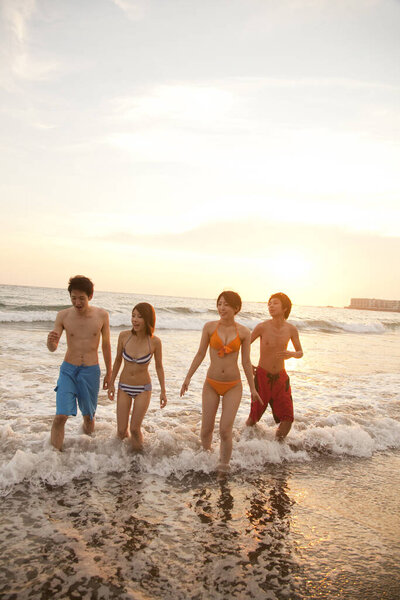 happy asian people  on beach at sunset time.