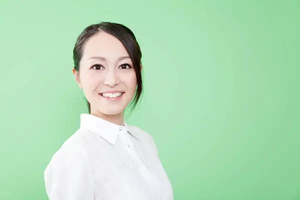 緑の背景を持つ若いアジアの女性 — ストック写真