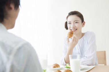 Güzel Asyalı kadın evde kocasıyla kahvaltı yapıyor.