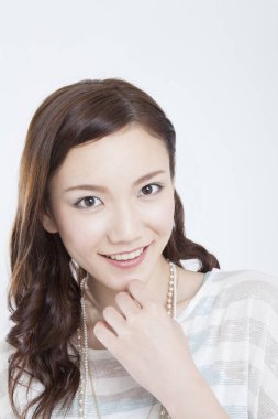 Beyaz arka planda gülümseyen bir kadın. 