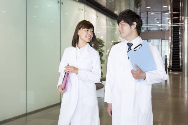 Beyaz önlüklü genç Asyalı öğrenciler.