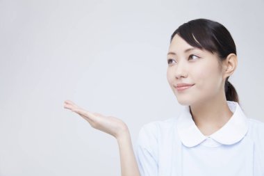 Beyaz arkaplanda elini gösteren genç bir kadın.