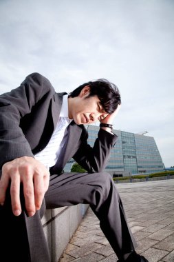 Stresli iş adamı bankta oturuyor