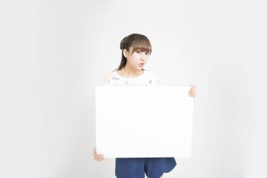Asyalı genç bir kadın izole edilmiş arka planda boş afiş tutuyor.