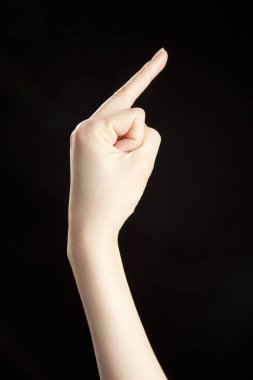 Siyah stüdyo arka planında kadın eli hareketi, yakın çekim. 