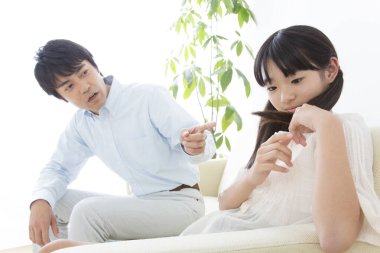 Kanepede oturan, azarlayan bir adam.