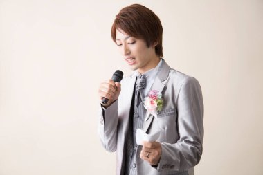 Mikrofonlu genç Asyalı yakışıklı damat. 