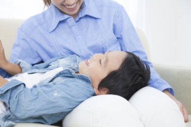 Stüdyoda poz veren Asyalı genç anne ve tatlı oğlunun portresi.