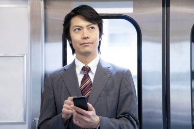 Yetişkin Japon iş adamının portresi metroda çalışacak.