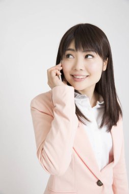 Beyaz arka planda telefonu olan genç bir iş kadını. 