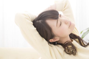 Güzel Asyalı kadın evde dinleniyor.