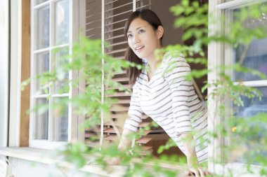 Pencereden bakan Asyalı kadın