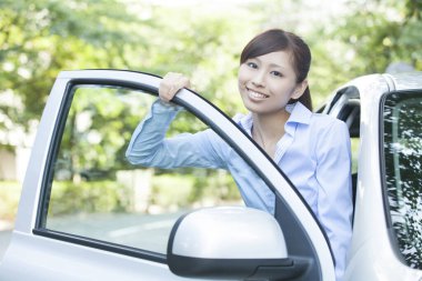 Yeni arabasıyla Asyalı kadın.