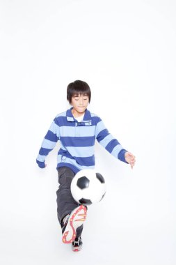 Futbol topu taşıyan Asyalı bir çocuğun portresi. 
