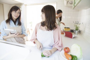 Mutfakta birlikte yemek hazırlayan üç kadın.