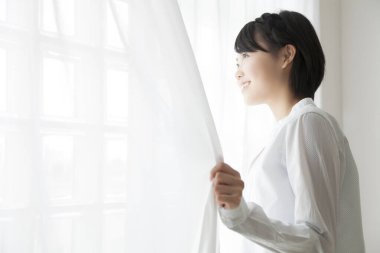 Pencerenin yanında duran genç kadın.