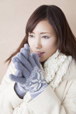 Kışlık giysili genç Asyalı kadın, stüdyo fotoğrafı.