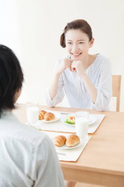 Güzel Asyalı kadın evde kocasıyla kahvaltı yapıyor.