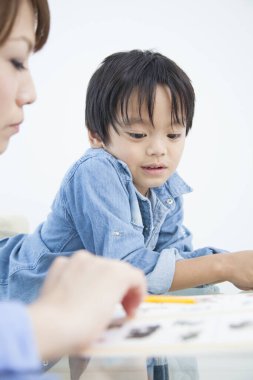 Genç Japon kadın oğluyla ev ödevi yapıyor.