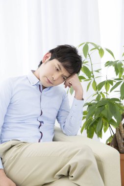 Evde yorgun yüzlü Asyalı bir adam var.