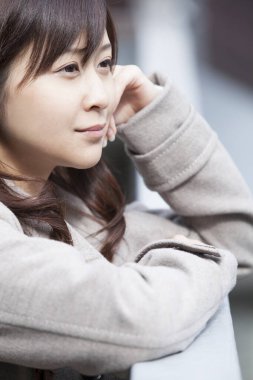 Genç ve güzel Asyalı bir kadının açık hava portresini kapat.