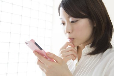 Cep telefonuna bakan bir kadın.