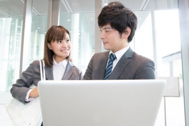 Genç iş adamları ofiste dizüstü bilgisayar kullanıyorlar.