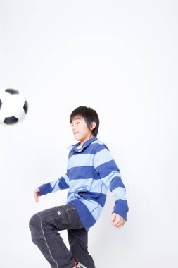 Futbol topu taşıyan Asyalı bir çocuğun portresi. 