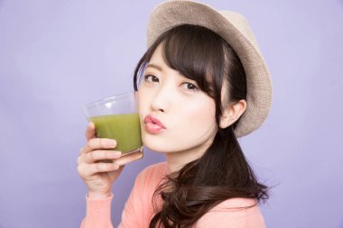 Elinde yeşil kibrit çayı tutan kadın.