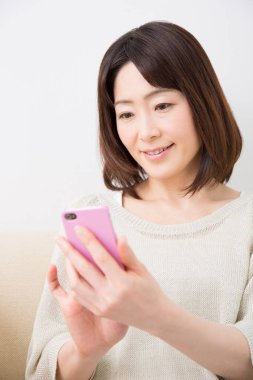 Evde bir akıllı telefon kullanan kadın