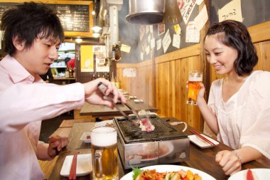 İçeceklerin tadını çıkarırken çift et kızartıyor.