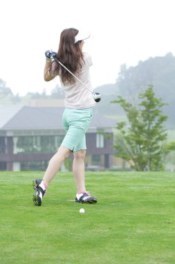 young woman playing golf on the course