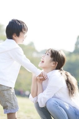 Anne ve oğlu parkta oynuyorlar. 